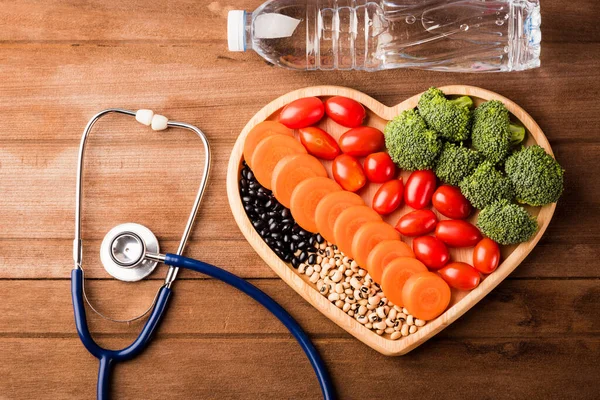 心板木 胡萝卜 西兰花 西红柿 医生听诊器和木制桌子上的塑料水瓶中新鲜有机水果和蔬菜概览 健康生活方式饮食概念 — 图库照片