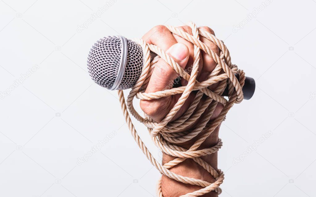 Hand holding microphone and have roped on fist hand on white background, Human rights day concept