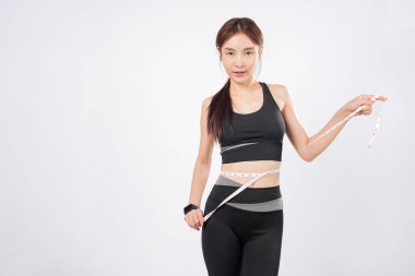 İnce vücudunu neşeyle sarıp ölçün. Bu mutlu ve sağlıklı kadın spordan esinlenen dönüşümünden kendine güven yayıyor. izole stüdyo beyaz arkaplan