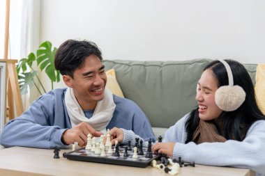 Kış çifti, evde oturup satranç oynayan mutlu insanlar, gerçek kahkahaları paylaşıyorlar, soğuk kış günlerinde sıcak anılar yaratıyorlar..