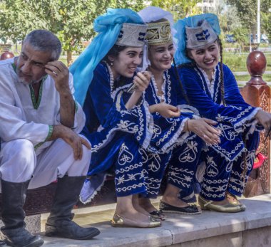 Buhara, Özbekistan - Jule 30, 2018: halk Buhara Kavun Festivali bankta oturan dansçılar