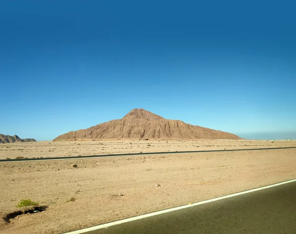 Вулкан в пустыне и дорога — стоковое фото