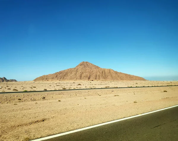Vulcano nel deserto e una strada — Foto Stock