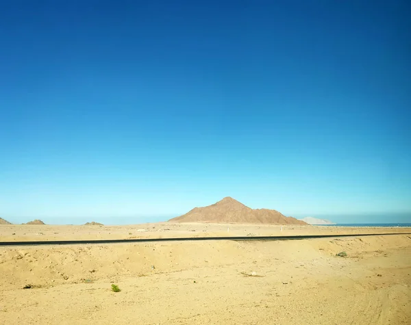 Vulcão no deserto e uma estrada — Fotografia de Stock