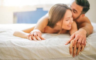 Genç çift öpüşme ve seks yatakta - romantik ve samimi anlar yatak odasında - aşk, ilişki, cinsel kavramı olan tutkulu aşık aşık