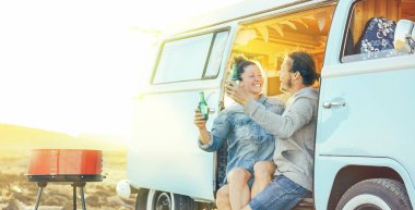 Seyahat çift eğleniyor kendi vintage camper mini van - mutlu bir yolculuk - kavramı tatil yaşam tarzı ve aşk sırasında gün batımında Barbekü keyfini onların evde beslenen hayvan insanlarla oturup bira içmek