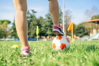 Stadyumda topla antrenman yapan genç bayan futbolcu - tren sahasında egzersiz yapan sporcu kadın - sportif insan yaşam tarzı kavramı