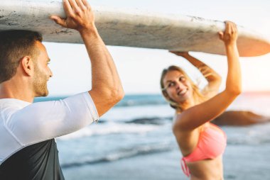 Bir surfboard holding ve birbirlerine - arkadaşlar eğlenmeye bakarak mutlu sevgi dolu çift bir tatil sırasında - insanlar sörf ilişki, seyahat, yaşam tarzı konsept spor