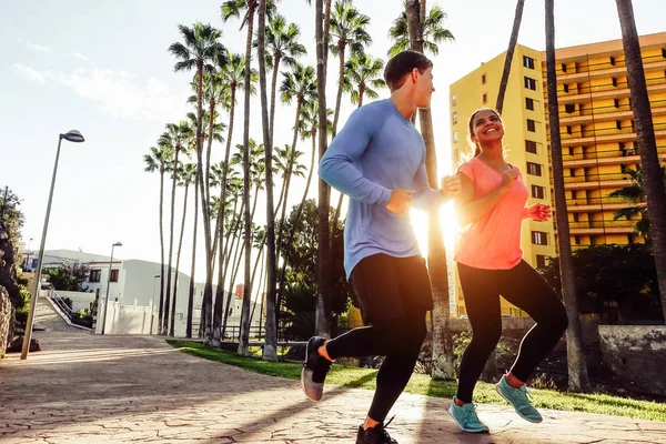 Healthy young couple jogging together  at sunset time outdoor - Happy sportive people running in the city - Relationship, sport, youth lifestyle concept