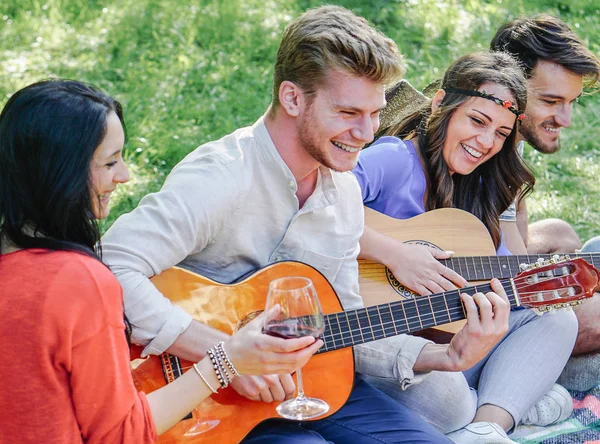 Grupo Amigos Tocando Guitarras Riendo Mientras Beben Vino Tinto Sentado — Foto de Stock
