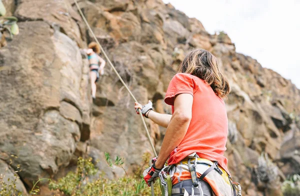 Man Ger Bistånd Till Kvinna Som Klättrar Upp Berget Cliff — Stockfoto