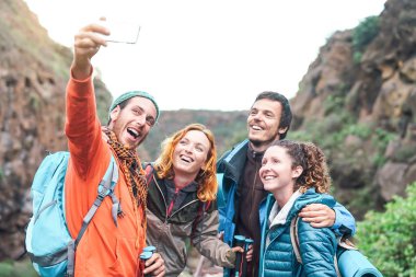Mutlu arkadaş trekking ve yeni teknoloji eğilimleri ile - spor hiking, teknik ve sosyal medya kavramı, eğlenceli sahip dağ - bin yıllık genç insanlar üzerinde hareket eden smartphone kamera ile fotoğraf yapma