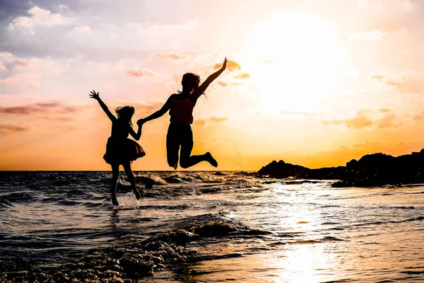 Счастливые Мать Дочь Прыгают Вместе Вдоль Морской Воды Силуэт Любящей — стоковое фото