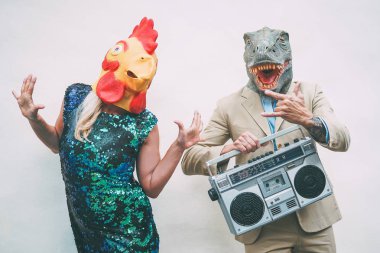 Çılgın üst düzey çift giyen tavuk ve açık - dans ederken t-rex maskesi olgun trendy insanlar kutlama ve boombox - maskeli balo komik tatil saçma kavramı ile müzik eğlence
