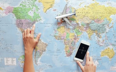 Dünya Haritası ve cep telefonu pusula uygulaması - macera, teknoloji, turizm, kavramı kullanarak ve insanların yaşam tarzı seyahat onun sonraki seyahat hedef gösteren genç turist kadının Üstten Görünüm