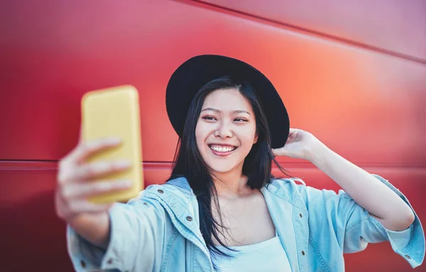 Happy Asian girl doing a video story with mobile smart phone outdoor - Chinese woman web influence having fun with new trends social networks app - People, millennial generation and technology concept