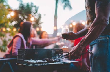 Mutlu bir aile barbekü akşam yemeği gece - çatıda yakın yaşam tarzı Barbekü Izgara açık - gıda, kavramı pişirme dövme adamın elini insanlar ve yaz hafta sonu etkinlikleri