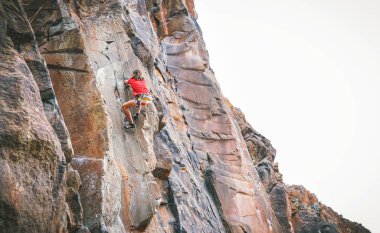 Atletik adam bir kaya duvarı - eğitim ve bir kanyon dağda - kavramı aşırı spor, insanların sağlık yaşam tarzı ve dağcılık gerçekleştirme dağcı