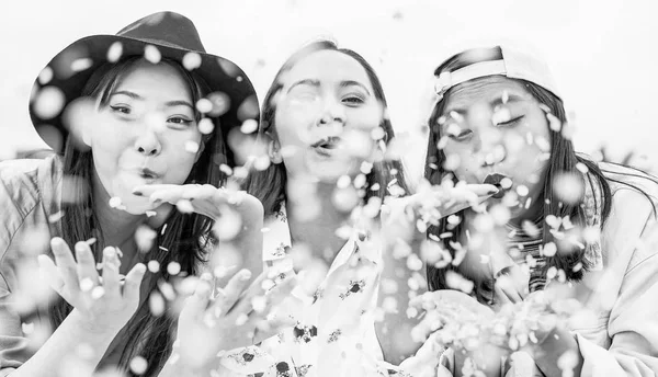Felices amigos asiáticos divirtiéndose lanzando confeti al aire libre - Jóvenes de moda celebrando en el evento del festival fuera - Amistad, fest, entretenimiento y concepto de estilo de vida juvenil — Foto de Stock