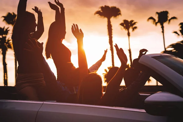 Group of friends having fun in convertible car during road trip at sunset - Young travel people driving a cabriolet during summer holidays - Happiness, vacation and youth lifestyle concept — Stock Photo, Image