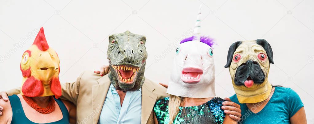 Happy family wearing different carnival masks - Crazy people having fun wearing on chicken, carlino, t-rex and unicorn mask - Concept of bizarre, humor and masquerade holidays lifestyle party