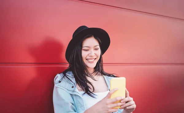 Chica china feliz usando el teléfono móvil al aire libre - Mujer influencer social asiática divirtiéndose con las nuevas tendencias aplicaciones de teléfonos inteligentes - Generación z, medios de comunicación, tecnología y juventud millennial people lifestyle —  Fotos de Stock