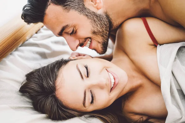 Feliz pareja romántica teniendo sexo - Jóvenes amantes durante los juegos previos tener momentos tiernos e íntimos en la cama - Personas, sexual, amor y concepto de relación — Foto de Stock