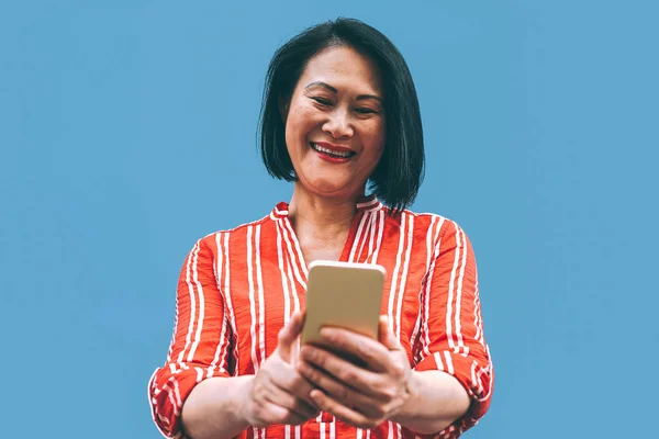 Mujer mayor asiática divirtiéndose con teléfono móvil al aire libre - Mujer china feliz usando teléfono inteligente fuera - Ancianos, social, tecnología y personas concepto de estilo de vida —  Fotos de Stock