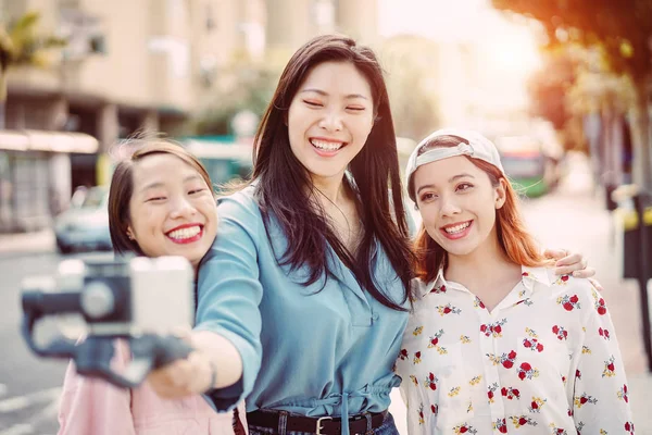 Amigos asiáticos felices haciendo historia de vídeo en el centro de la ciudad - Jóvenes de moda grabando con el teléfono inteligente al aire libre - Amistad, tecnología, estilo de vida juvenil y concepto de redes sociales — Foto de Stock