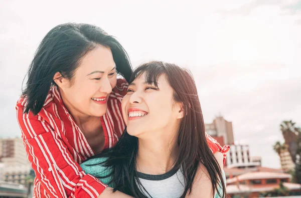 Feliz madre e hija divirtiéndose al aire libre - Familia asiática disfrutando de tiempo juntos al aire libre - Concepto de estilo de vida, amor y paternidad — Foto de Stock