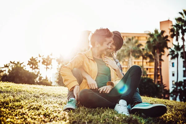 Feliz pareja gay abrazando y riendo juntos en el parque al aire libre - Jóvenes lesbianas teniendo un momento tierno al atardecer fuera - Personas, Lgbt, bisexualidad, relación concepto de estilo de vida — Foto de Stock