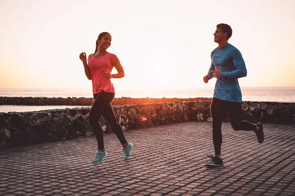 Fit par jogging nästa stranden-sportiga unga människor som kör Workout session utomhus-hälsosam, ungdom och idrott aktivitet livsstil Concept — Stockfoto
