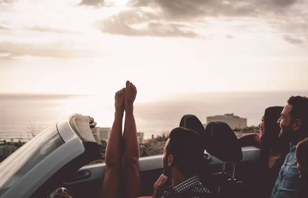 Happy friends driving on convertible car at sunset - Young people having fun during vacation road trip in cabriolet - Friendship, travel and youth lifestyle concept — Stock Photo, Image