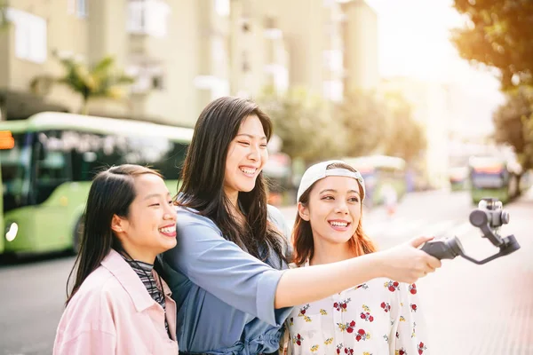 Chicas asiáticas felices haciendo historias de video en el centro de la ciudad - Amigos jóvenes de moda filmando con teléfono inteligente al aire libre - Amistad, tecnología, estilo de vida de los jóvenes y concepto de redes sociales — Foto de Stock