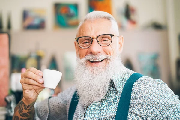 Счастливый пенсионер, пьющий кофе в баре - Хипстерский пожилой мужчина во время кофе-брейка - концепция Livepeople — стоковое фото