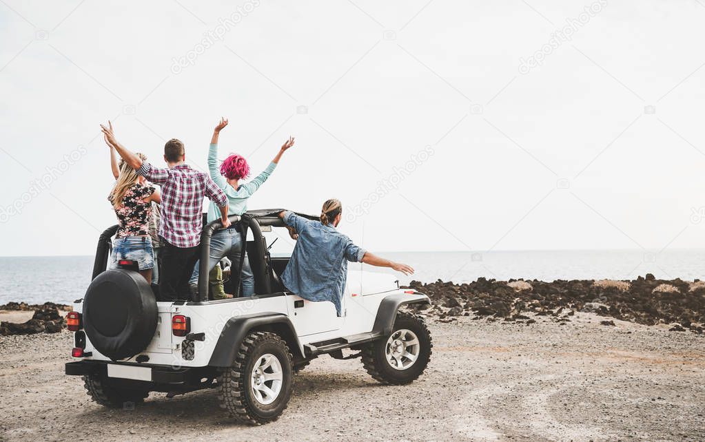 Group of friends driving off road convertible car during roadtrip - Happy travel people having fun in vacation - Friendship, transportation and youth lifestyle holidays concept