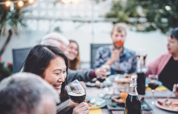Mutlu aile tezahürat ve birlikte açık yemek - farklı yaş ve etnik kökene sahip insanlar barbekü akşam yemeği partisinde eğlenmek - yiyecek ve içecek, emekli ve gençler kavramı — Stok fotoğraf
