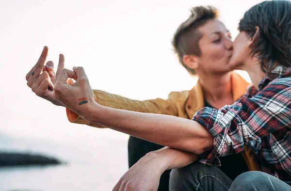 Leszbikus pár csók, miközben ünnepli LMBT büszkeség-meleg szerelmes, amelyek pályázati pillanatok a strandon-a homoszexualitás, a büszkeség és a kapcsolat életmód koncepció — Stock Fotó