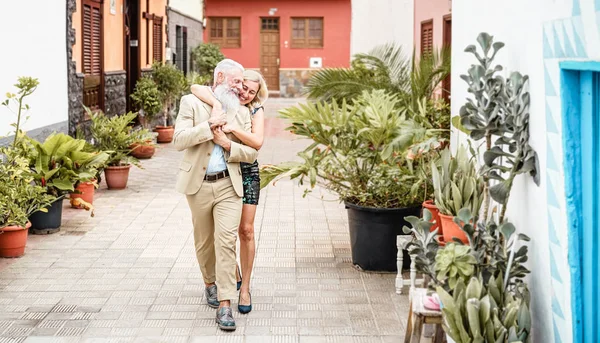 Счастливая пожилая пара на открытом воздухе - Пенсионеры весело прогуливаются по городу - Любовь, отношения и пожилой образ жизни — стоковое фото