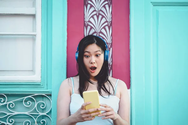 Chica asiática feliz escuchando música con auriculares al aire libre - Joven mujer china jugando su música favorita de la lista de reproducción de su aplicación de teléfono inteligente móvil - Generación milenaria y concepto de tecnología — Foto de Stock