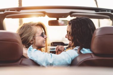 Genç ve mutlu bir çift tropikal bir şehirde yolculuk yapıyor - İnsanlar yeni yerler keşfederken trend arabalarında hassas anlar yaşıyorlar - ilişki ve gençlik tatili konsepti