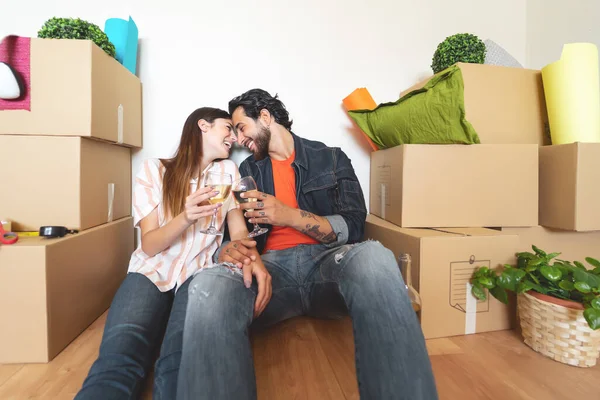 Happy young couple moving in new home first time - Man and woman having celebrating with champagne in new property house - Change apartment day and people lifestyle relationship concept