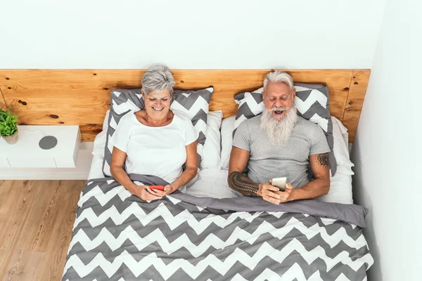 Pasangan Senior Yang Bahagia Menggunakan Smartphone Mobile Bawah Selimut Tempat — Stok Foto
