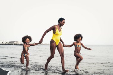 Yaz tatilinde plajda mutlu bir Afrikalı aile Afro-Amerikalı tatilde eğleniyor.