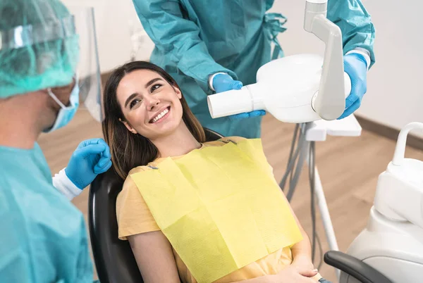Mężczyzna Dentysta Operujący Młodą Uśmiechniętą Kobietę Klinice Stomatologicznej Koncepcja Pomocy — Zdjęcie stockowe