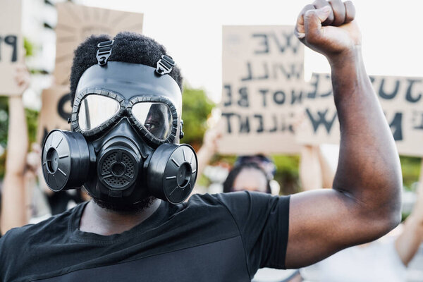 Activist wearing gas mask protesting against racism and fighting for equality - Black lives matter demonstration on street for justice and equal rights - Blm international movement concept