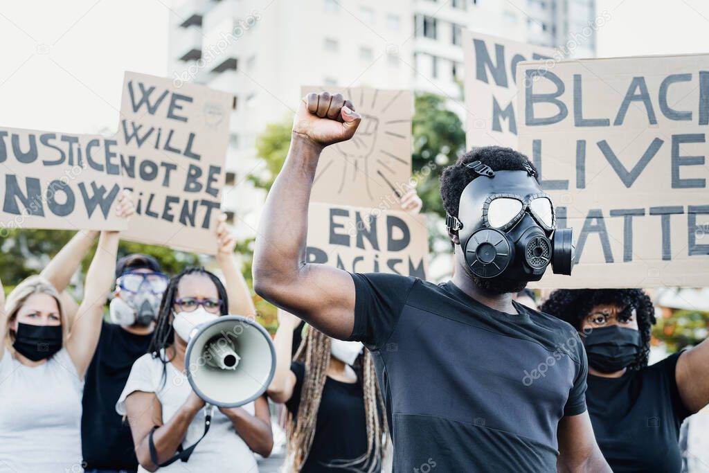 Activist wearing gas mask protesting against racism and fighting for equality - Black lives matter demonstration on street for justice and equal rights - Blm international movement concept