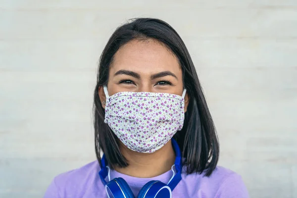 Young woman wearing face mask portrait - Latin girl using protective facemask for preventing spread of corona virus - Health care and pandemic crisis concept