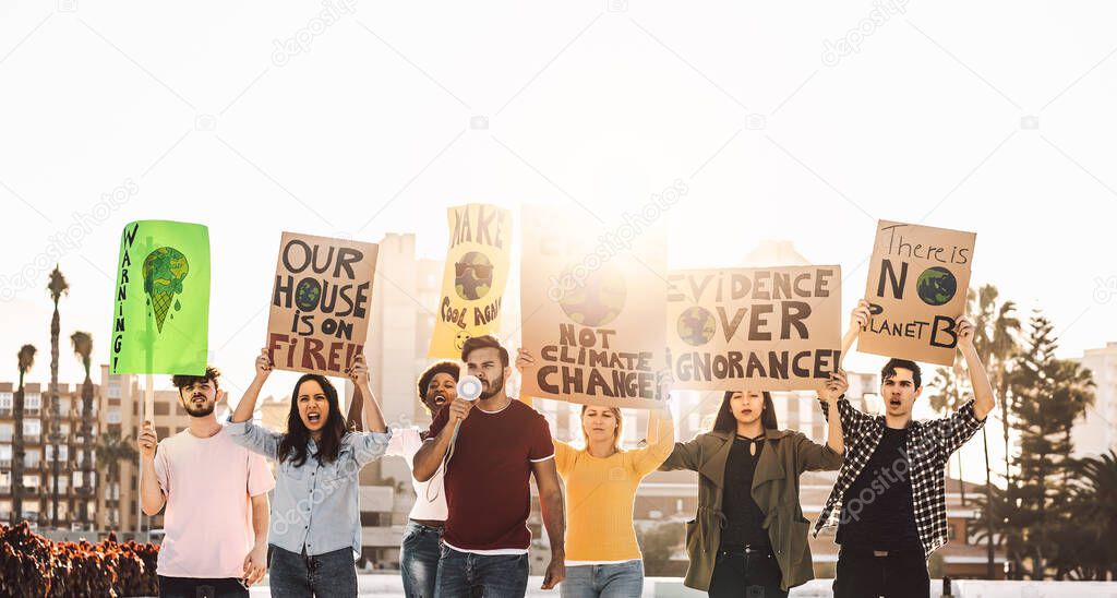 Demonstrators group protesting against plastic pollution and climate change - Multiracial people fighting on road holding banners on environments disasters - Global warming concept