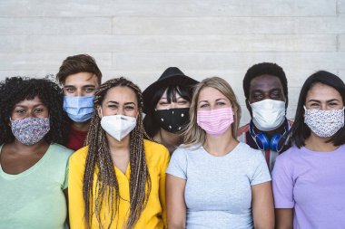 Corona virüsü salgınını önlemek için yüz maskesi takan grup genci - farklı yaş ve kültür portresi olan milenyum arkadaşları - Coronavirus hastalığı ve çok ırklı gençlik kavramı